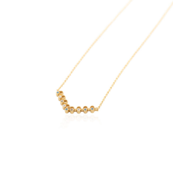 Angled view of the Molyvos necklace in 18K yellow gold, featuring repeating semicircles set with white, blue and brown diamonds on a fine gold chain.