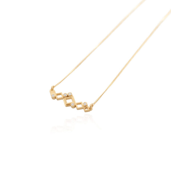 Angled view of the Melinda necklace in 18K yellow gold, featuring open rhombus shapes in different sizes with white diamonds.