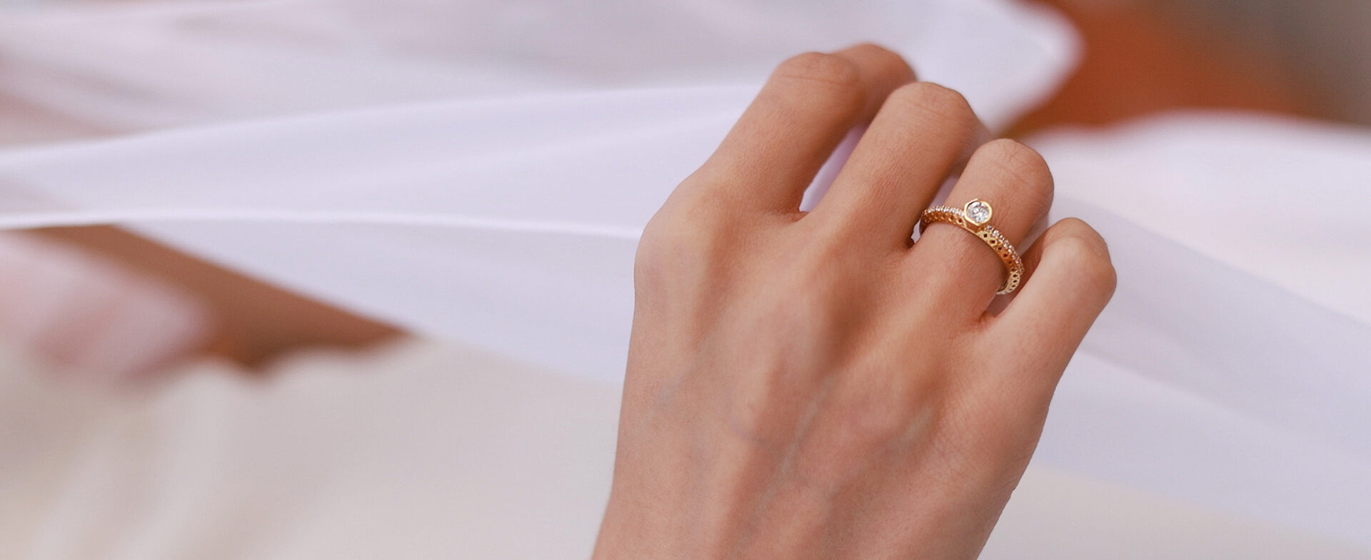 18K gold solitaire engagement ring with a 4 mm diamond, worn with a wedding band by Elsa Mouzaki.