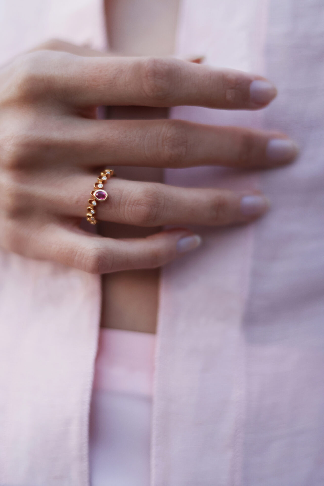 Close-up of a hand wearing an 18K gold ring with ruby and diamonds from the Mytilene Fine Epirroes collection.